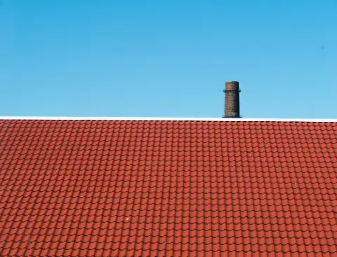 Red pantile roof with white ridge flashing.