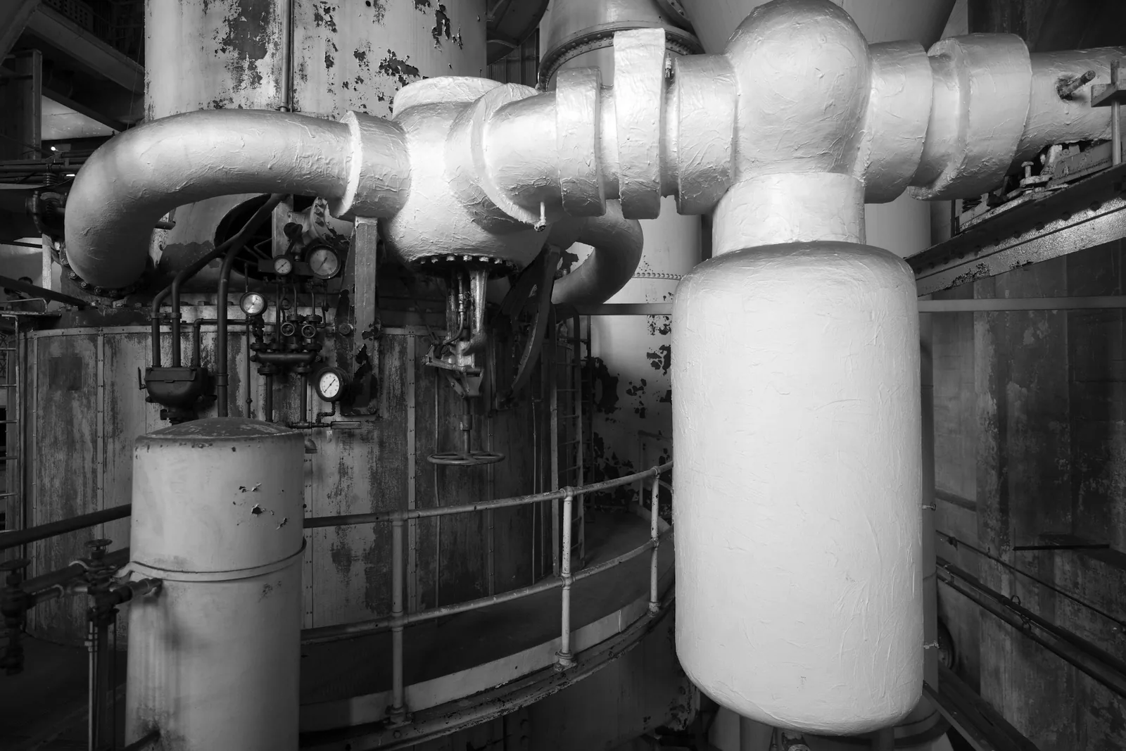 Large insulated pipework and a valve in a plant room.