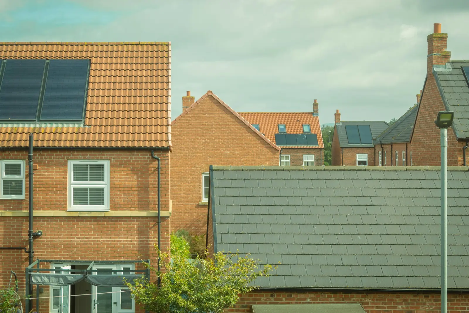 Solar panels sit on the pantile roof above a washing line strung across the back doors.