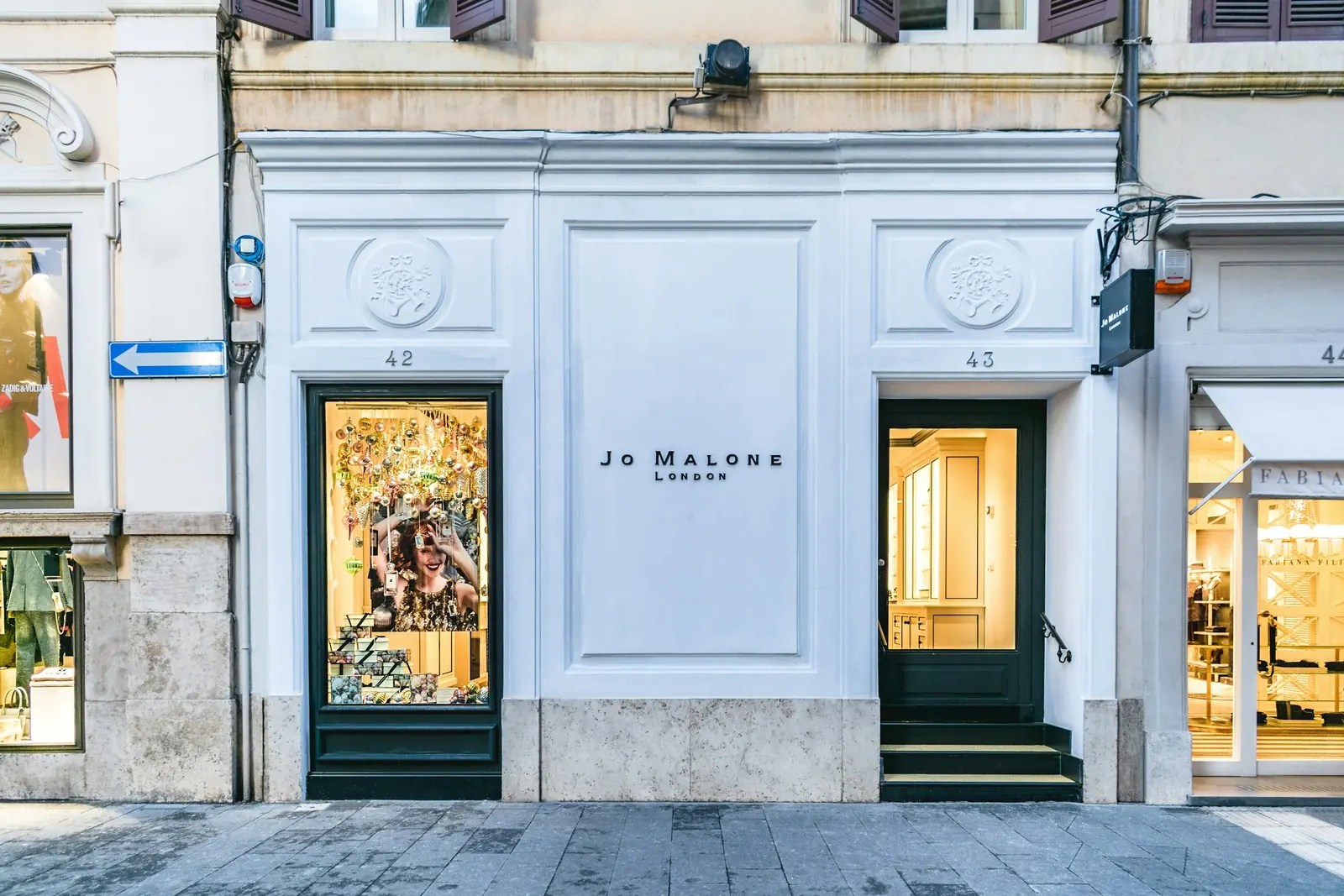 A painted shop front with a display window on a street.