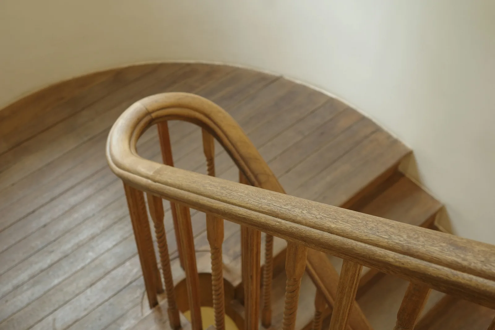 A wooden staircase with a curved handrail.