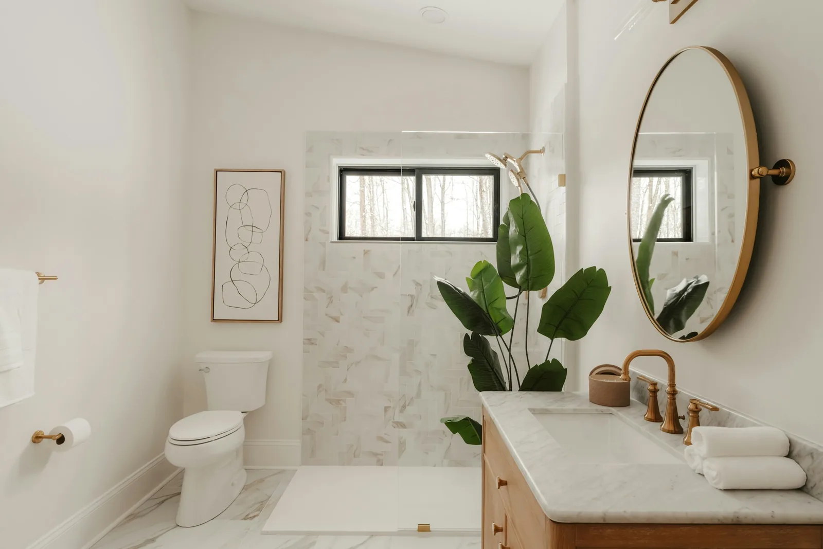 A bathroom with marble tiling and a large plant.