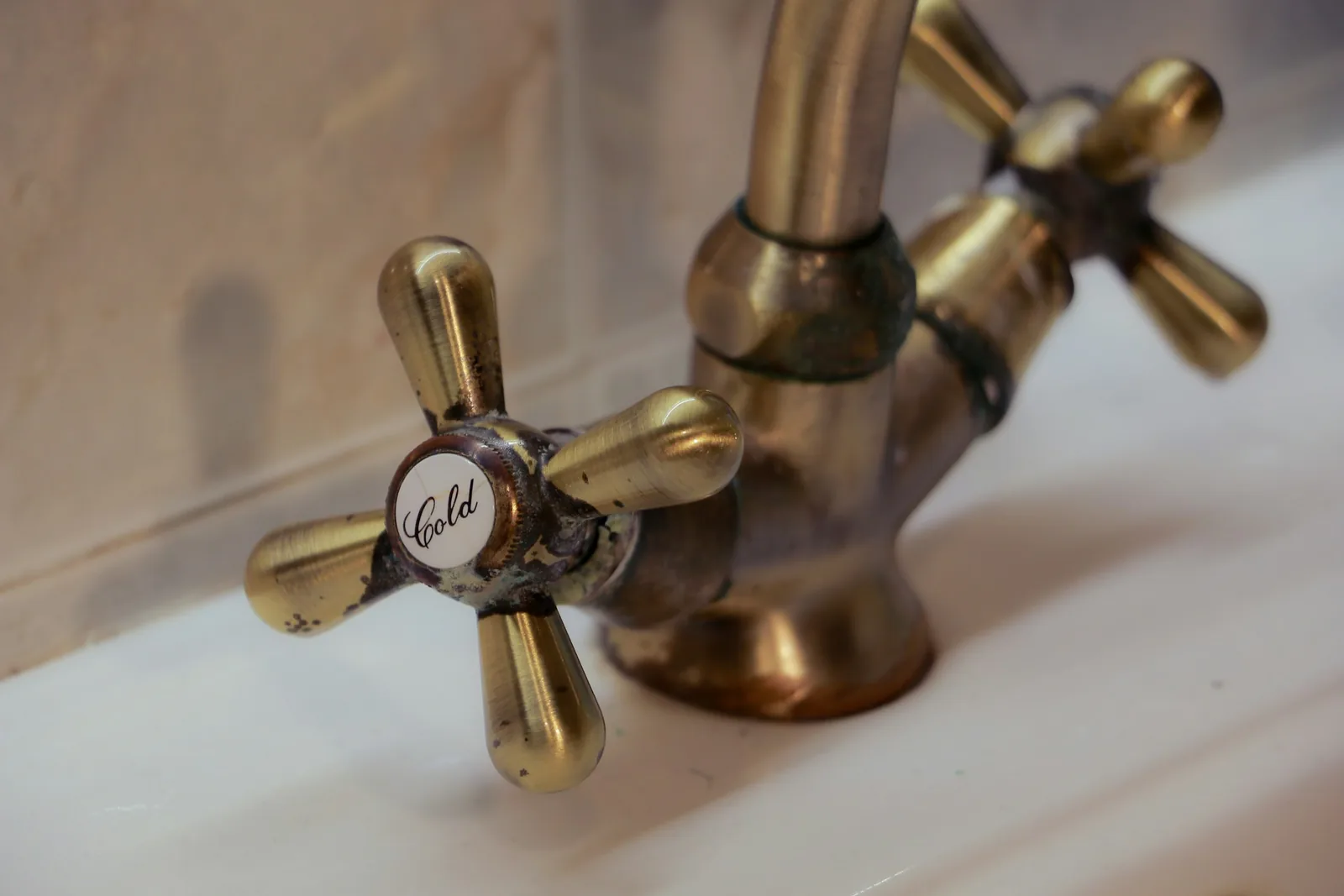 A close view of a brass cross-head tap on a basin.