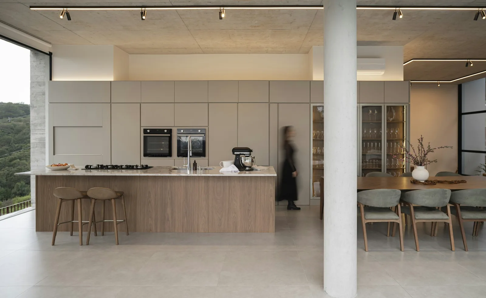 An open-plan kitchen and dining area with large windows.