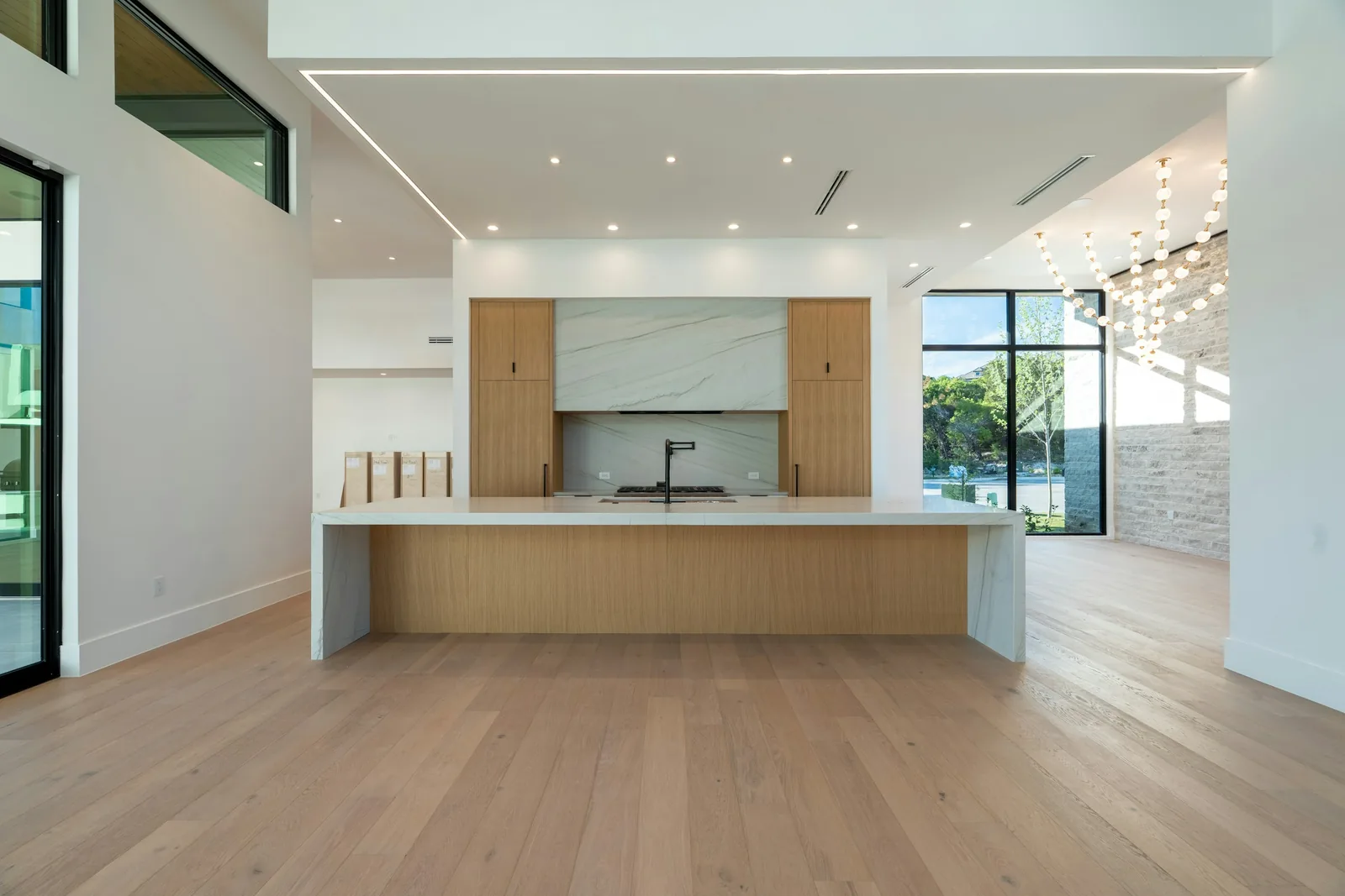 A kitchen with a large island and pale timber cabinetry.