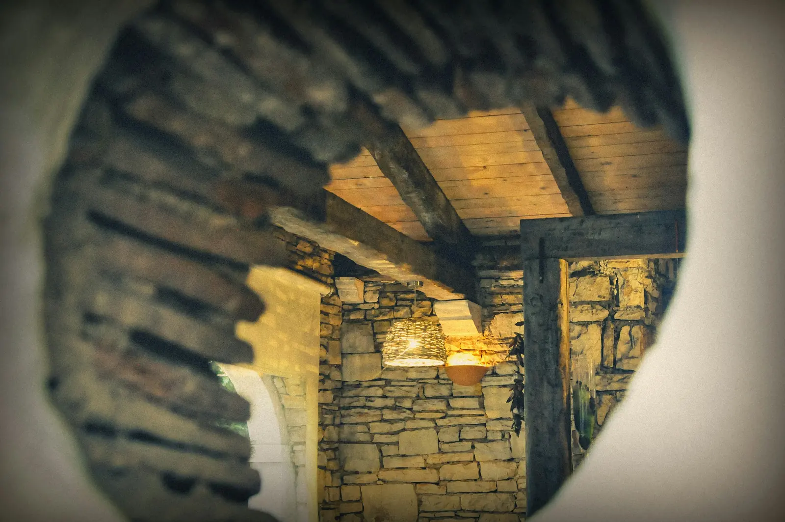 A room with a stone wall and a timber ceiling.