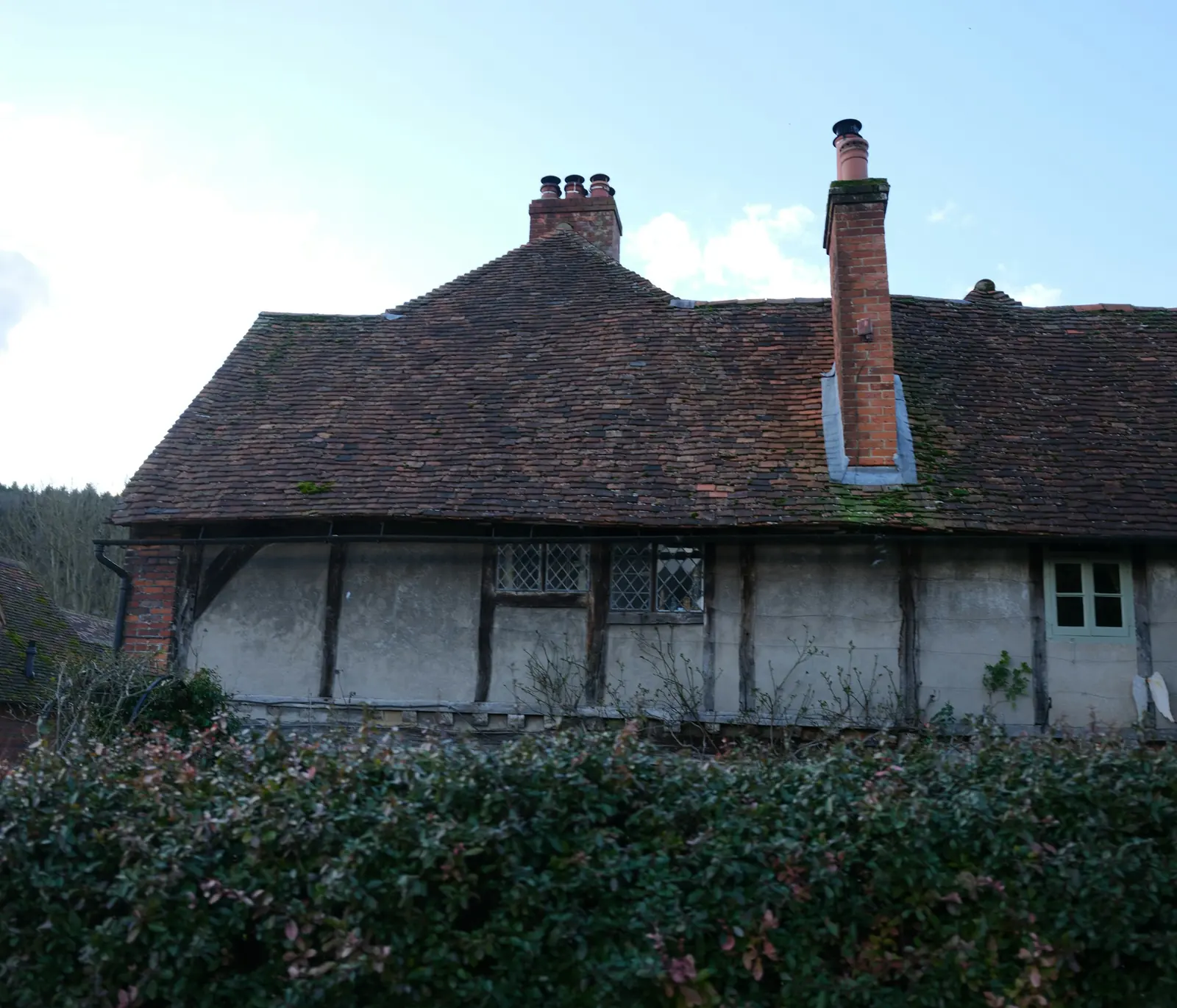 An old timber-framed cottage with a tiled roof.