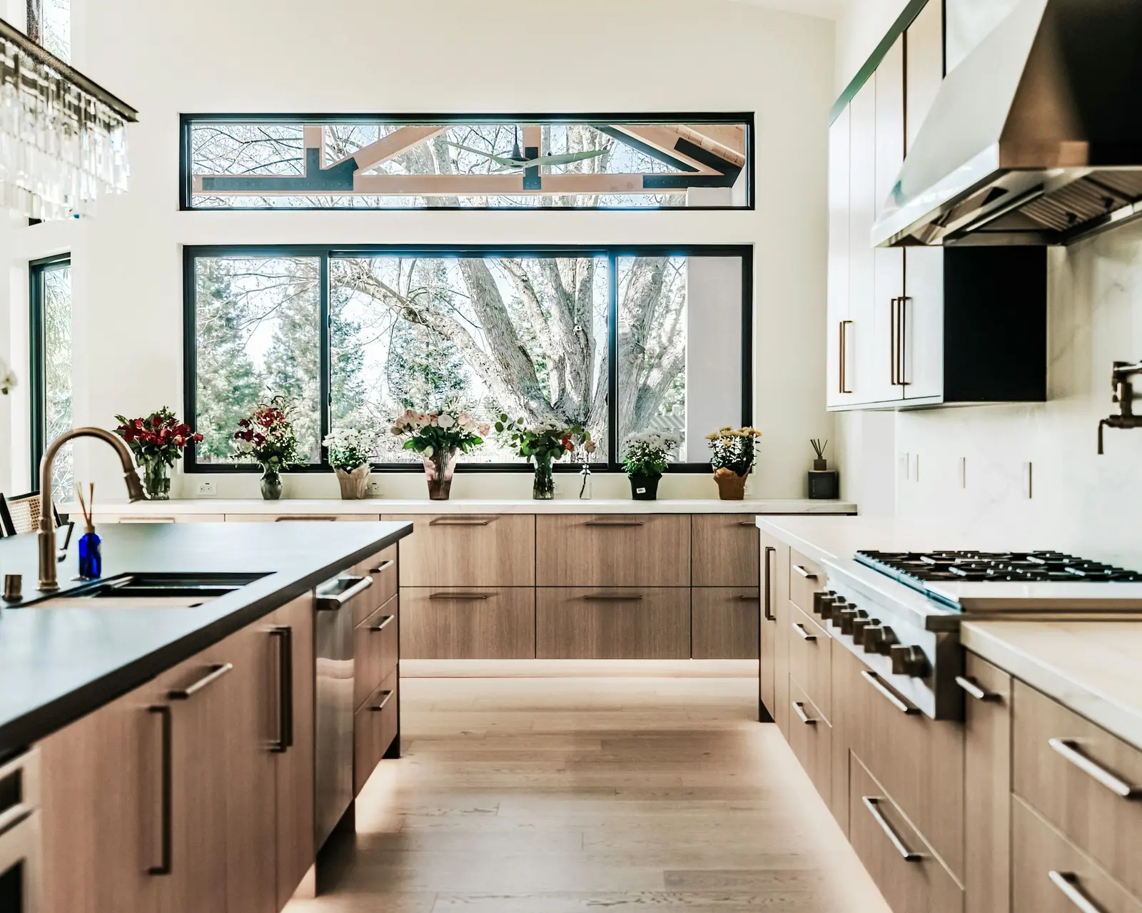 A kitchen with wood cabinets and large windows onto the garden.