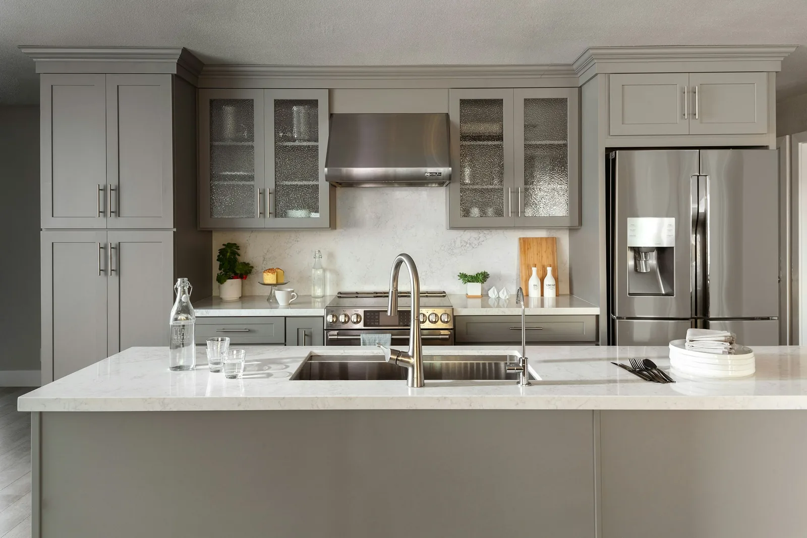 A grey shaker kitchen with a sink and integrated appliances.