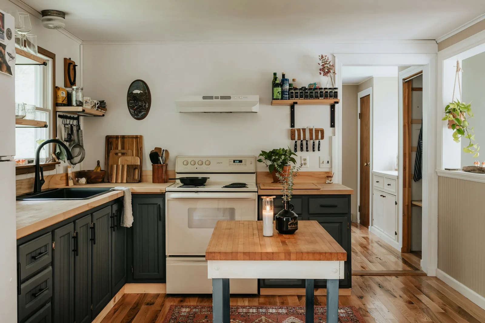 A kitchen with a butcher block worktop and open shelving.