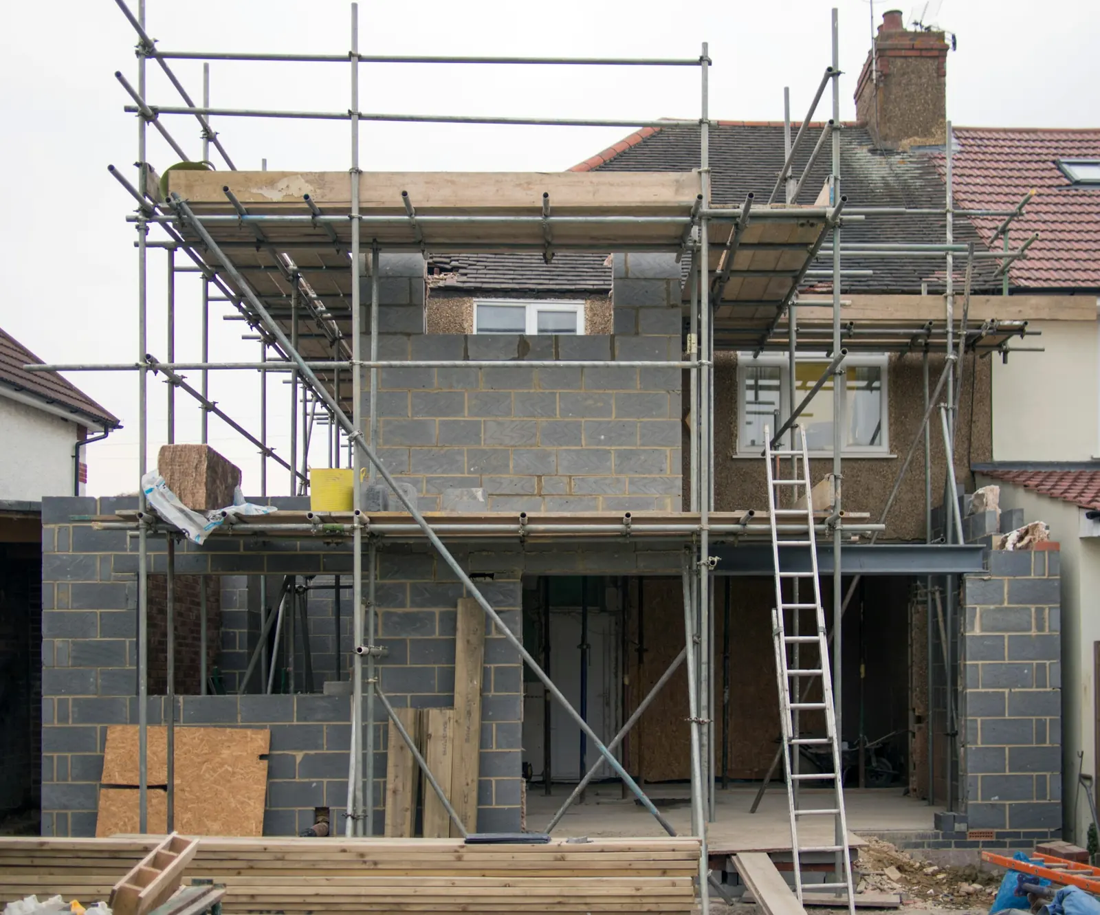 A house under construction behind scaffolding.