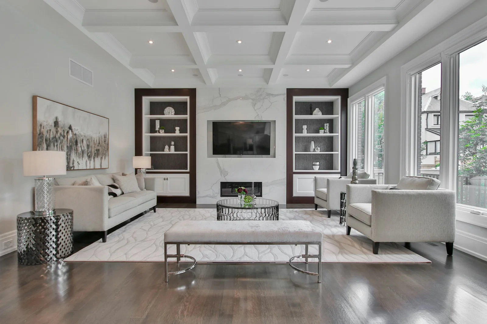 A living room with a marble fireplace and pale sofas.