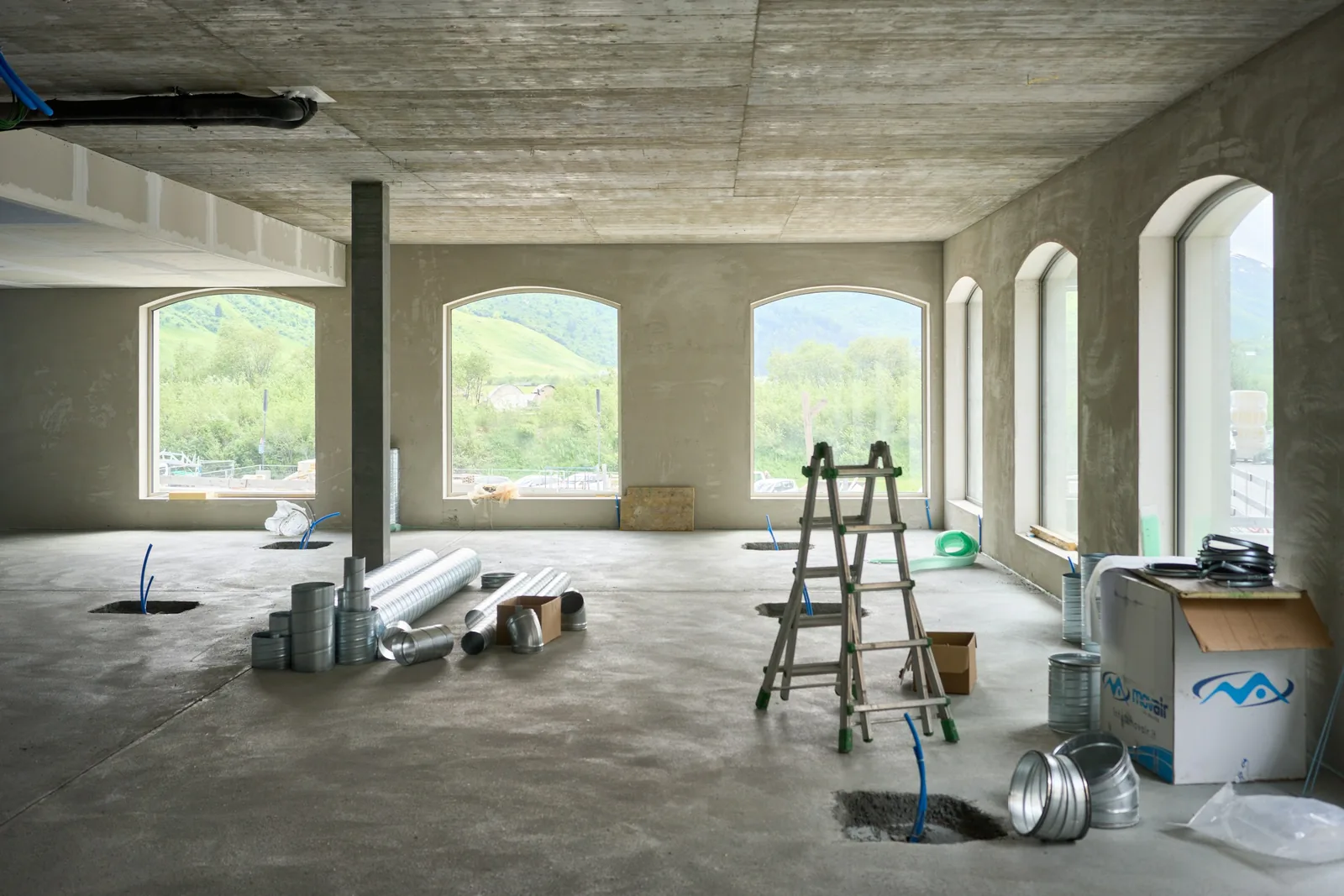 A large room stripped back mid-refurbishment with a ladder.